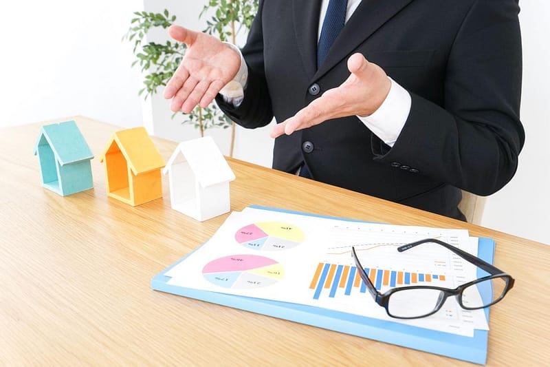 tree coloured houses on a table with a graph and chart demostrating choosing the right house