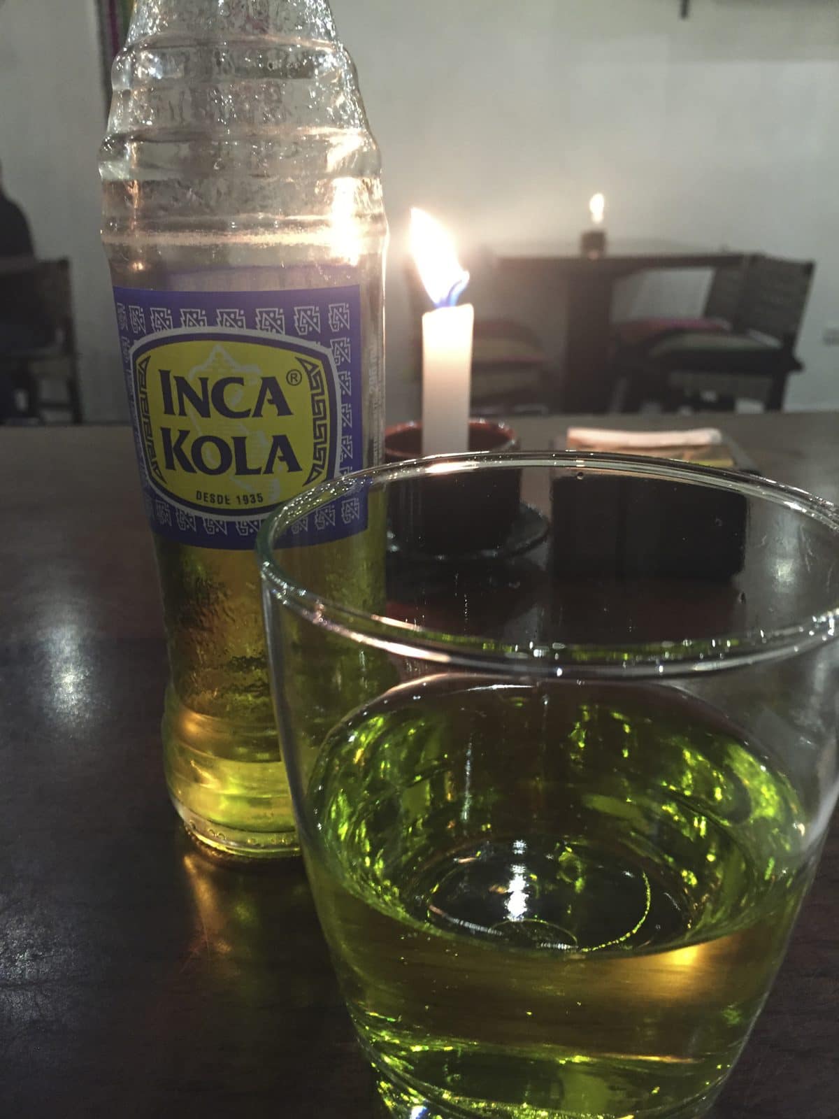 A bottle of bright yellow Inca Kola poured into a glass in Peru