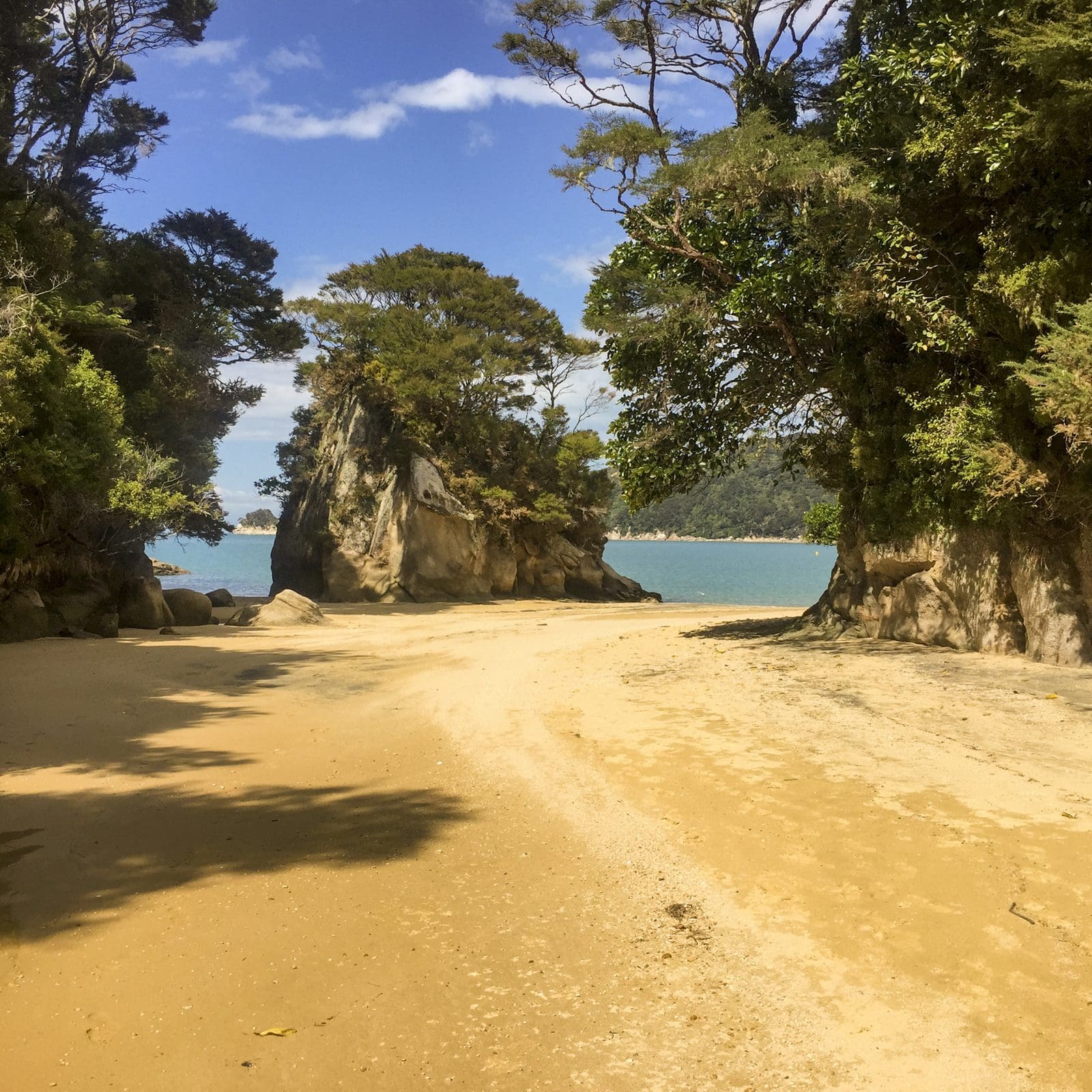 The Abel Tasman Coast Track winding between rocks onto the sand