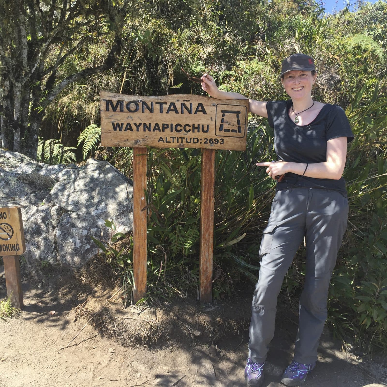 Julie at the Montana Wayna Picchu sign at the entrance to the climb