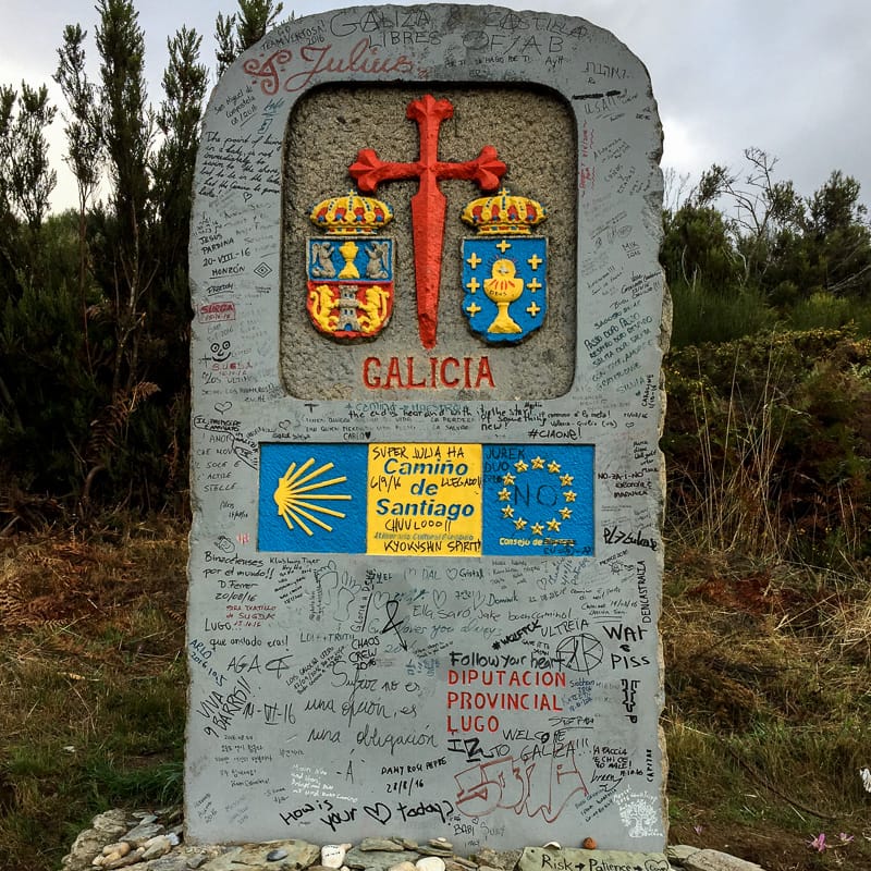 The Galicia border waymarker covered in messages left by pilgrims